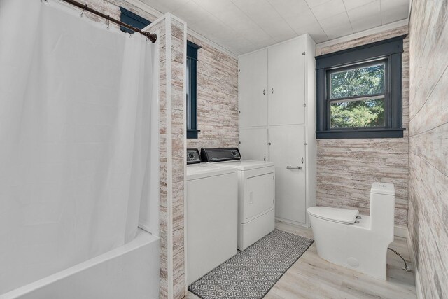 305 Pierson Ave, New Richmond, WI 54017 - bathroom with washing machine and clothes dryer, wood finished floors, toilet, and shower / bathtub combination with curtain