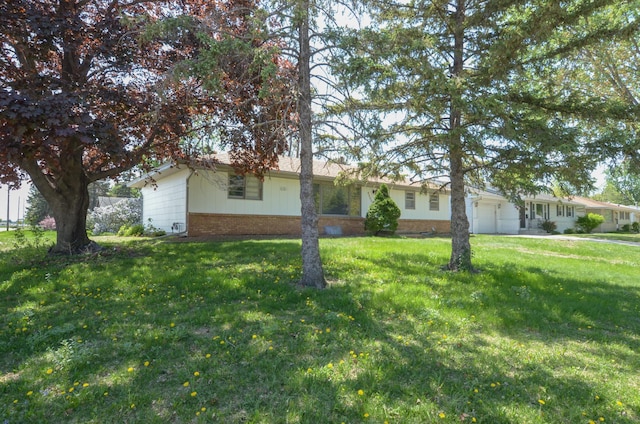 ranch-style house with a garage, brick siding, and a front lawn