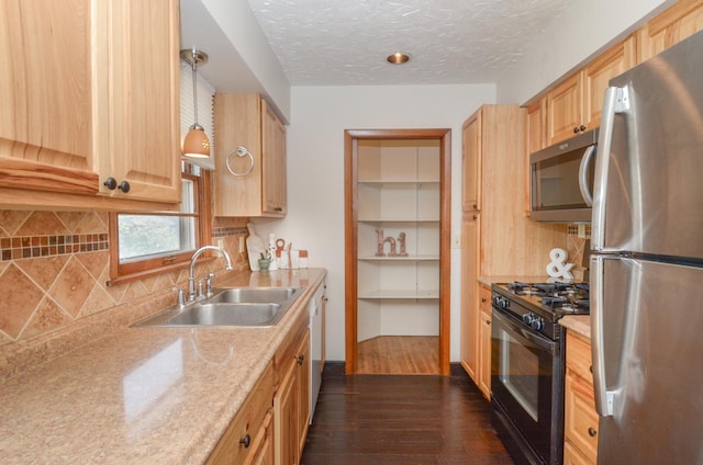 kitchen featuring appliances with stainless steel finishes, a sink, dark wood-style floors, light countertops, and light brown cabinetry