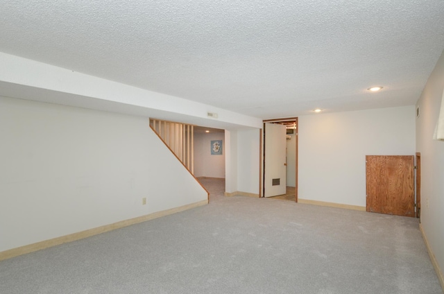finished below grade area featuring carpet, recessed lighting, a textured ceiling, and baseboards