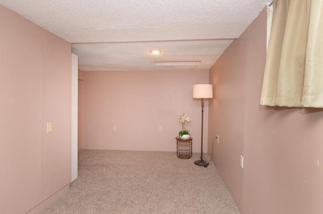 corridor with carpet floors and a textured ceiling