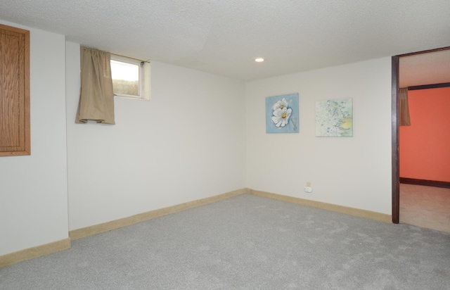 below grade area featuring carpet floors, a textured ceiling, recessed lighting, and baseboards