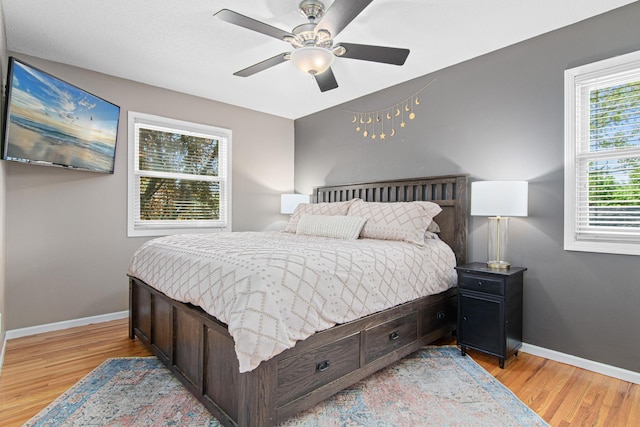bedroom featuring light wood-type flooring, baseboards, and a ceiling fan