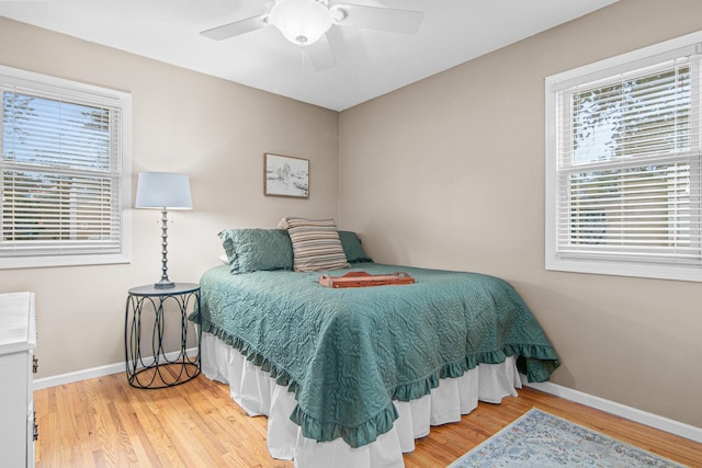 bedroom with wood finished floors, baseboards, and ceiling fan