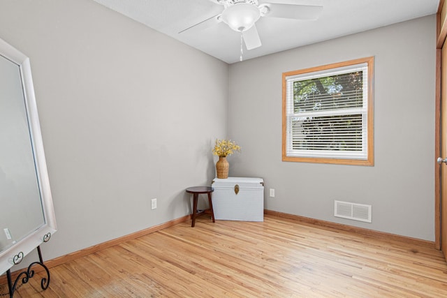 spare room featuring wood finished floors, baseboards, and a ceiling fan