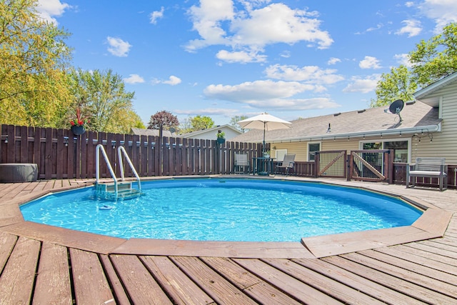 view of swimming pool featuring fence and a wooden deck