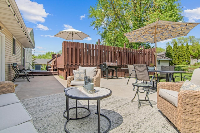 view of patio featuring outdoor dining area, grilling area, and fence