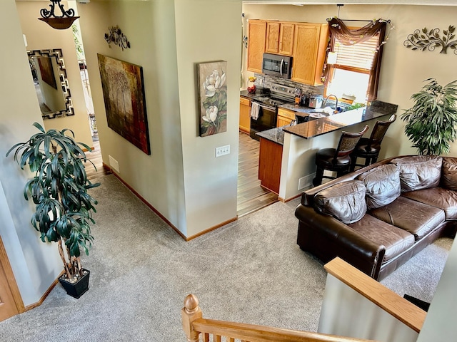 living area with light carpet and baseboards