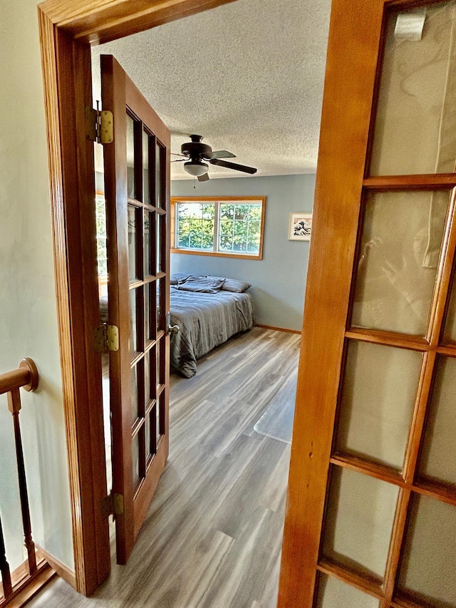 bedroom featuring ceiling fan, a textured ceiling, and wood finished floors