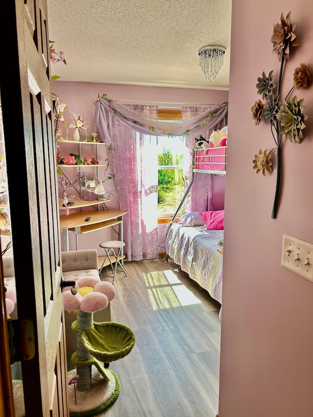 bedroom with a textured ceiling and wood finished floors