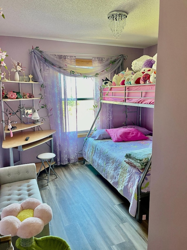 bedroom featuring a textured ceiling and wood finished floors