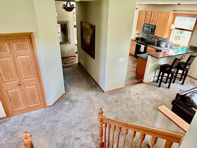 7263 Falmouth Curv, Shakopee, MN 55379 - kitchen with electric stove, carpet floors, baseboards, and a breakfast bar area