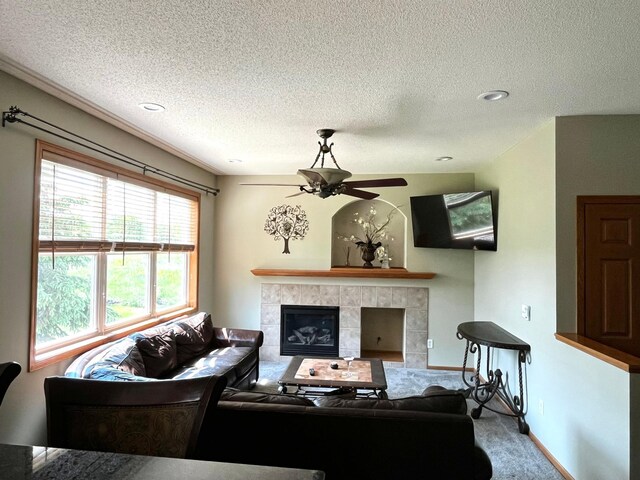 7263 Falmouth Curv, Shakopee, MN 55379 - carpeted living room with a tile fireplace, ceiling fan, a textured ceiling, and baseboards