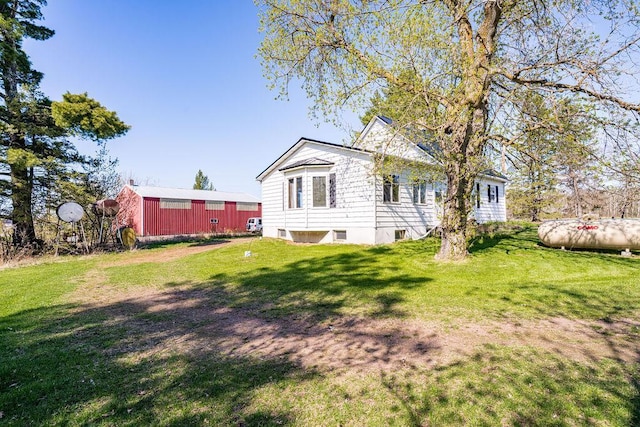 view of side of property featuring a yard and an outbuilding