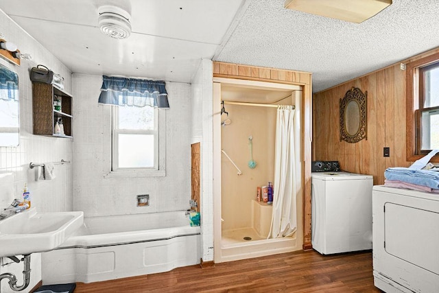 bathroom with curtained shower, wood finished floors, plenty of natural light, a sink, and wooden walls
