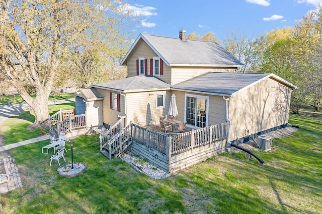 rear view of property with central AC, a deck, a yard, and a chimney