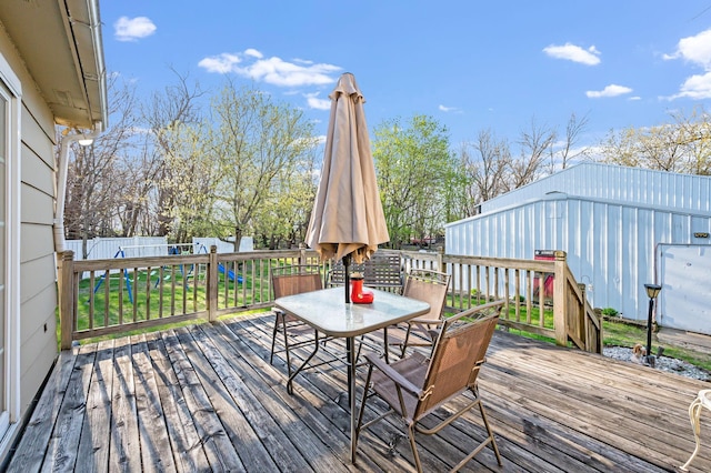wooden deck with outdoor dining space and a fenced backyard