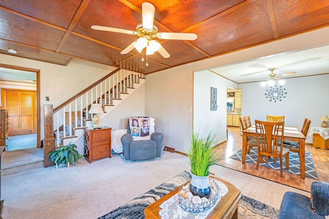 living area with a ceiling fan, stairs, carpet floors, and baseboards