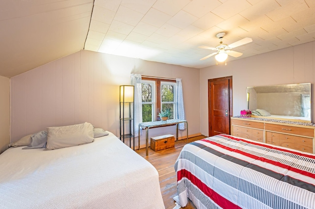 bedroom with wood finished floors, a ceiling fan, and vaulted ceiling