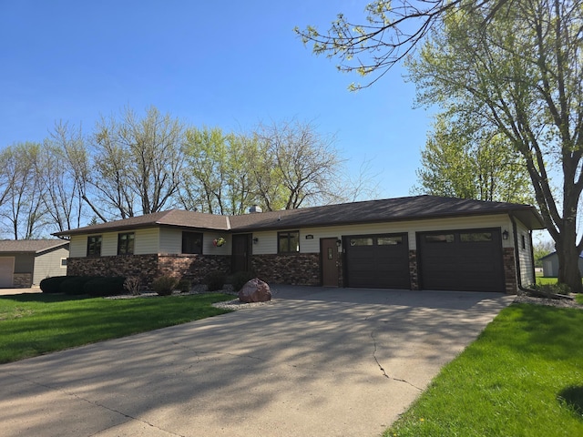 view of front of house featuring concrete driveway, a garage, and a front yard