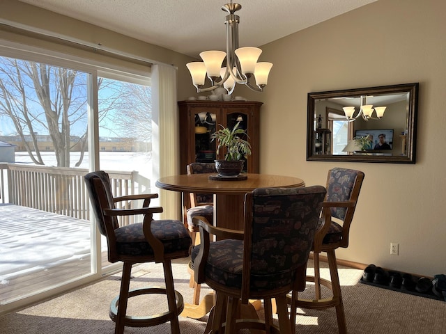 dining area featuring a water view, a notable chandelier, and carpet floors