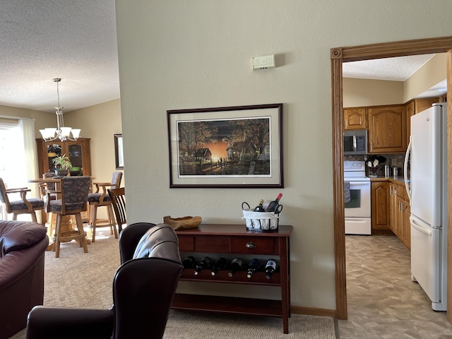 living room with light colored carpet, a textured ceiling, a chandelier, and baseboards