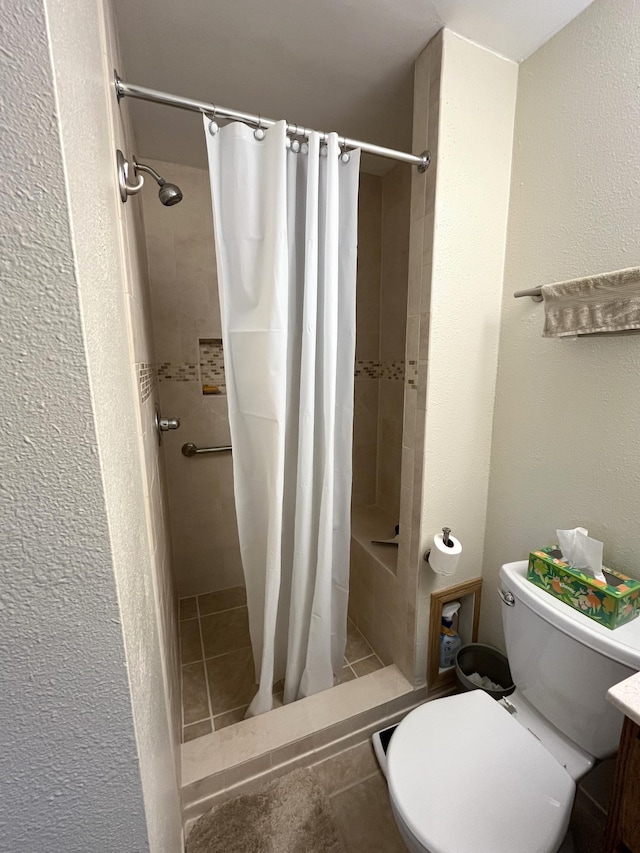 full bathroom with a shower stall, tile patterned floors, toilet, and a textured wall