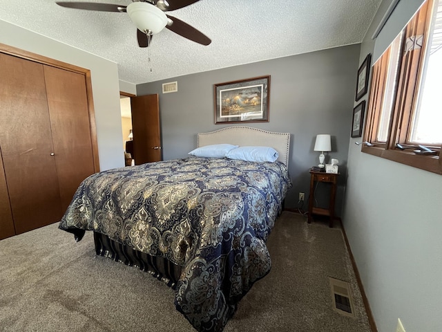 carpeted bedroom with ceiling fan, a closet, visible vents, and a textured ceiling
