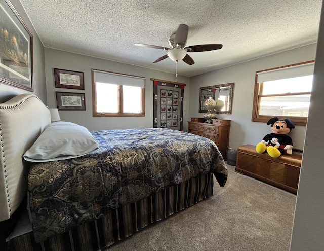 carpeted bedroom with multiple windows, a textured ceiling, and ceiling fan
