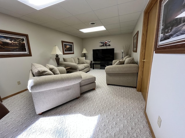 carpeted living area with baseboards, a drop ceiling, and visible vents