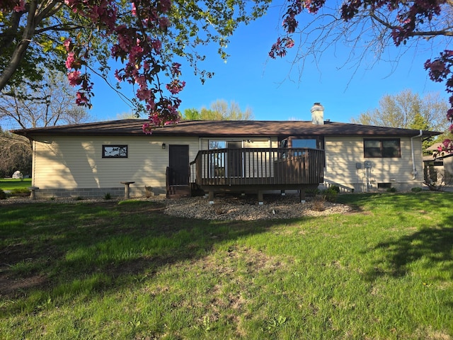 back of house featuring a lawn, a chimney, and a wooden deck