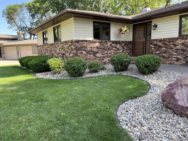 1085 20th St, Windom, MN 56101 - view of home's exterior with brick siding, a lawn, an attached garage, and a chimney