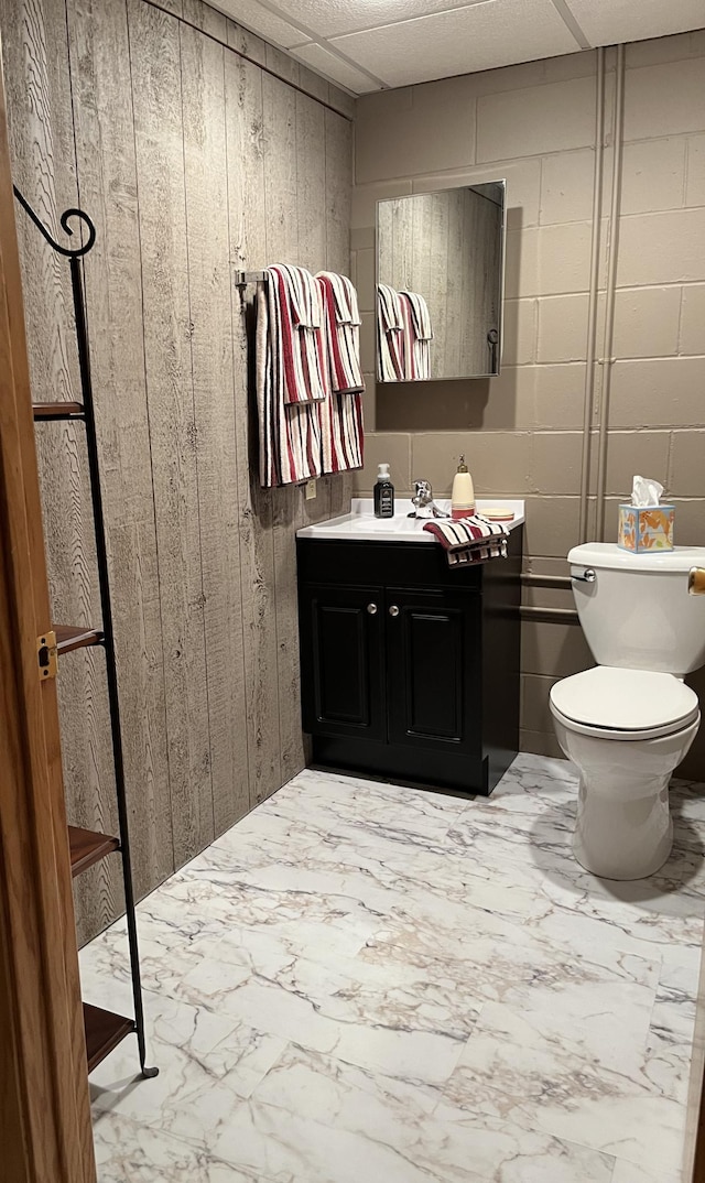 1085 20th St, Windom, MN 56101 - bathroom with vanity, marble look tile flooring, and wood walls