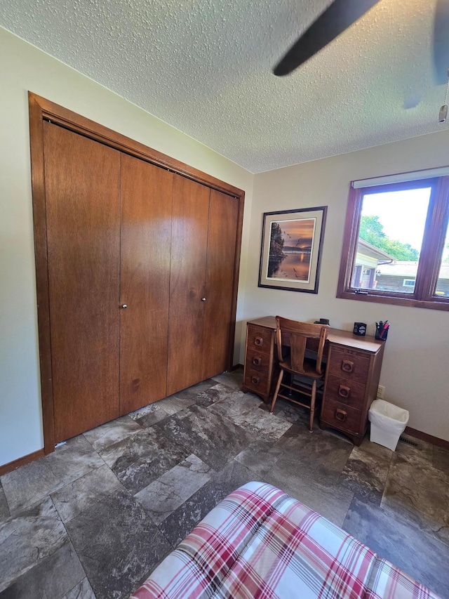 1085 20th St, Windom, MN 56101 - bedroom featuring a closet, a textured ceiling, and dark stone finish floors