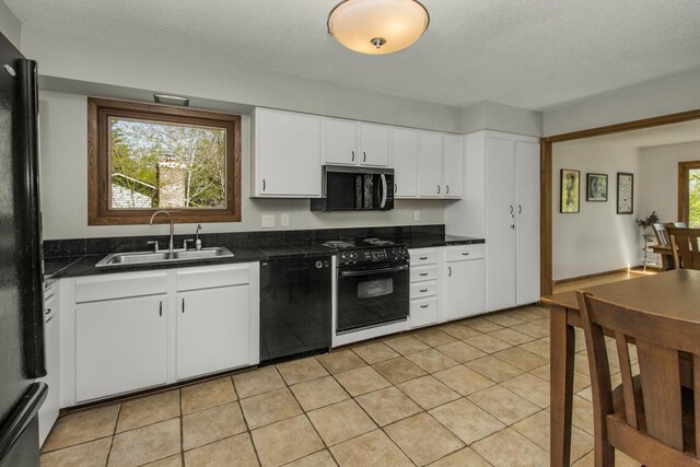 13056 Euclid Ave, Apple Valley, MN 55124 - kitchen with black appliances, dark countertops, white cabinets, a textured ceiling, and light tile patterned floors