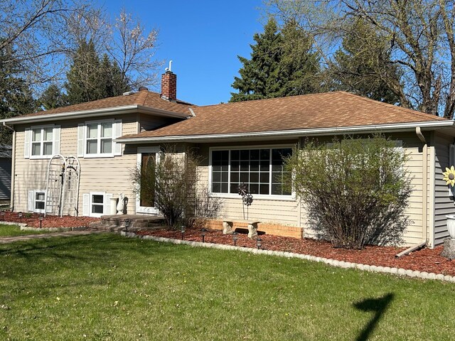 view of front of house featuring a chimney and a front lawn