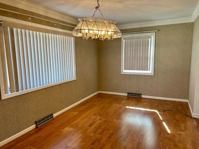 324 Maple Ave S, Thief River Falls, MN 56701 - empty room featuring wood finished floors, a chandelier, ornamental molding, and baseboards