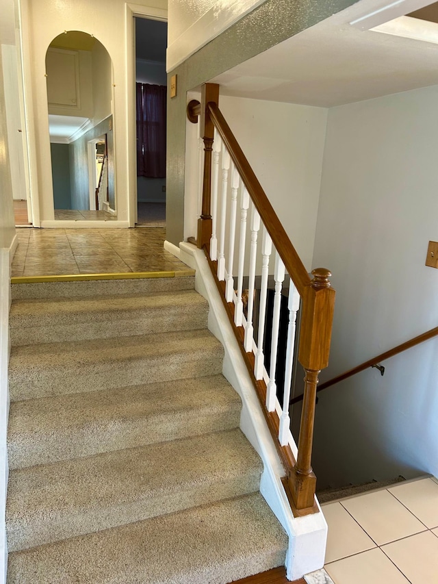324 Maple Ave S, Thief River Falls, MN 56701 - staircase featuring tile patterned flooring, baseboards, and arched walkways
