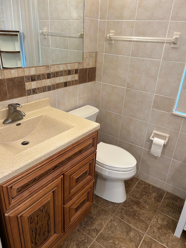 324 Maple Ave S, Thief River Falls, MN 56701 - half bathroom with tile walls, toilet, vanity, and decorative backsplash