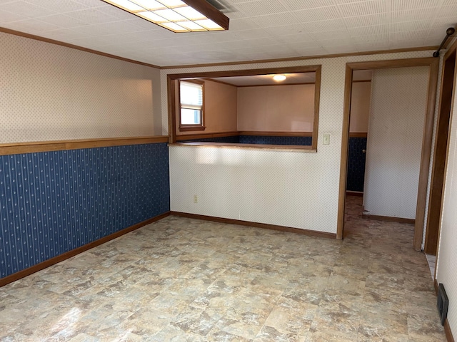 324 Maple Ave S, Thief River Falls, MN 56701 - empty room with stone finish flooring, ornamental molding, wallpapered walls, wainscoting, and baseboards