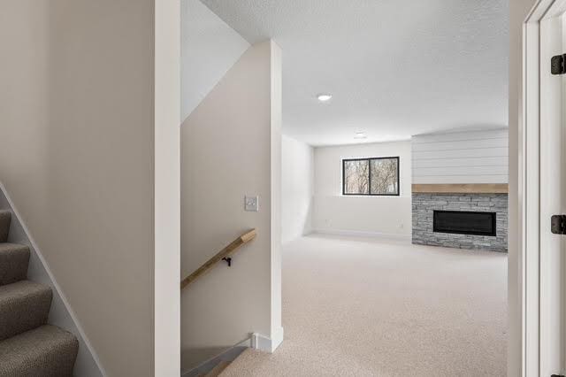2140 Arkwright St, Maplewood, MN 55117 - stairway featuring carpet floors, a stone fireplace, and baseboards