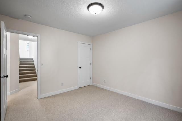 2140 Arkwright St, Maplewood, MN 55117 - unfurnished room with baseboards, light carpet, a textured ceiling, and a smoke detector