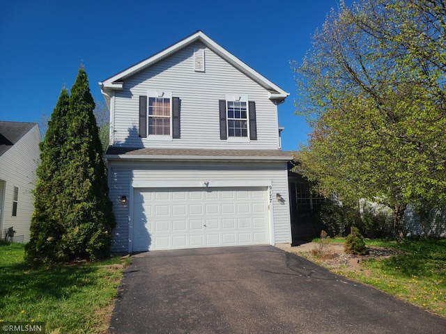 traditional-style home with an attached garage and asphalt driveway
