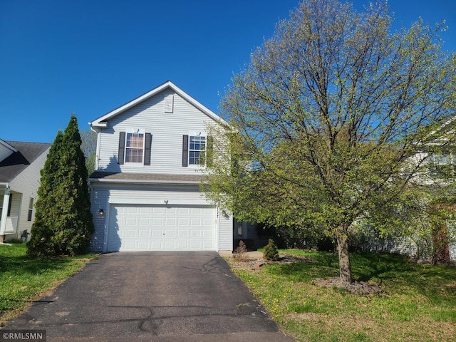 traditional-style home with a garage and asphalt driveway