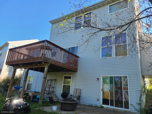 back of house featuring an outdoor fire pit, a wooden deck, and a patio area