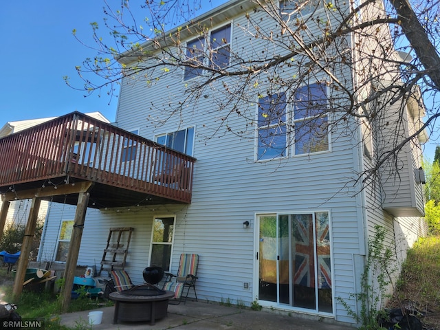 back of house with a fire pit, a deck, and a patio area