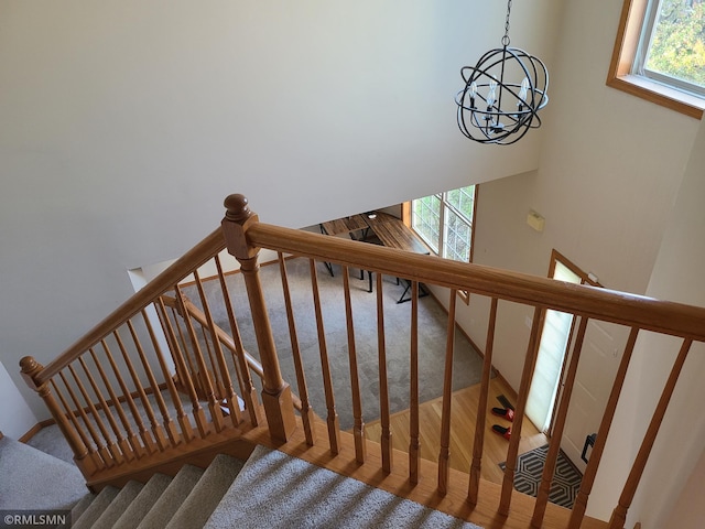 stairway featuring plenty of natural light and a chandelier