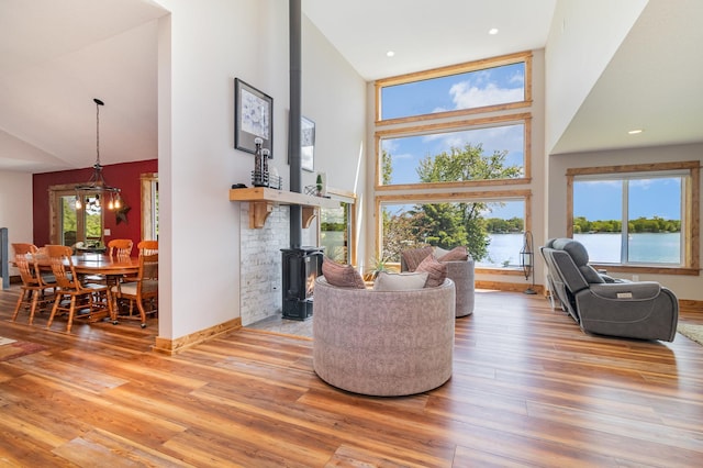 27667 Bay Shore Dr NW, Isanti, MN 55040 - living room featuring a wood stove, high vaulted ceiling, plenty of natural light, light wood-style flooring, and a water view