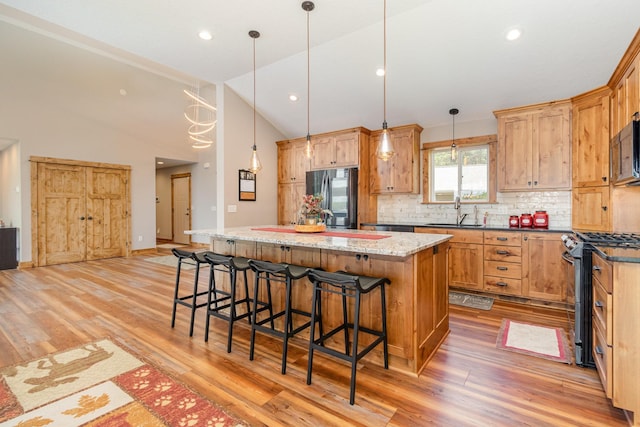 27667 Bay Shore Dr NW, Isanti, MN 55040 - kitchen with stainless steel appliances, a center island, tasteful backsplash, light wood-type flooring, and recessed lighting