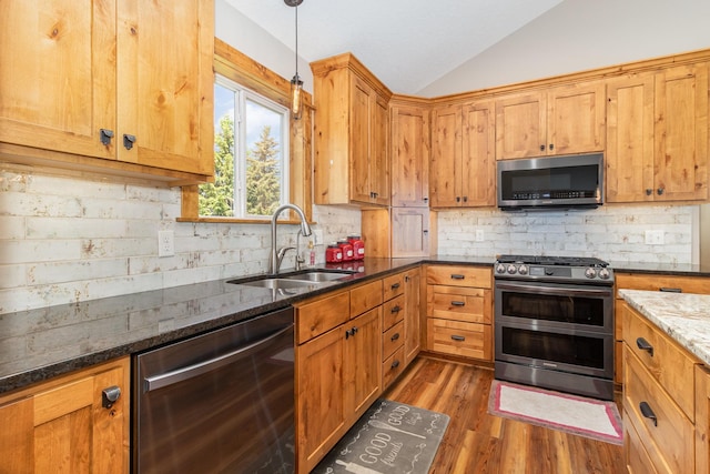 27667 Bay Shore Dr NW, Isanti, MN 55040 - kitchen featuring stainless steel appliances, a sink, lofted ceiling, backsplash, and wood finished floors